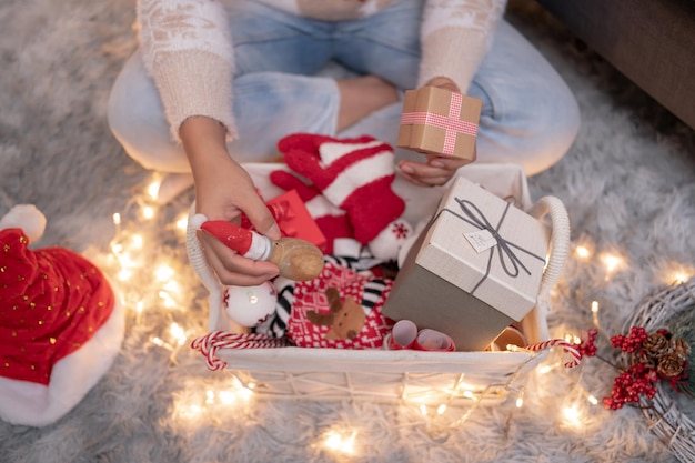 自宅でクリスマスと新年のパーティーのための贈り物とプレゼントを持つ女性。