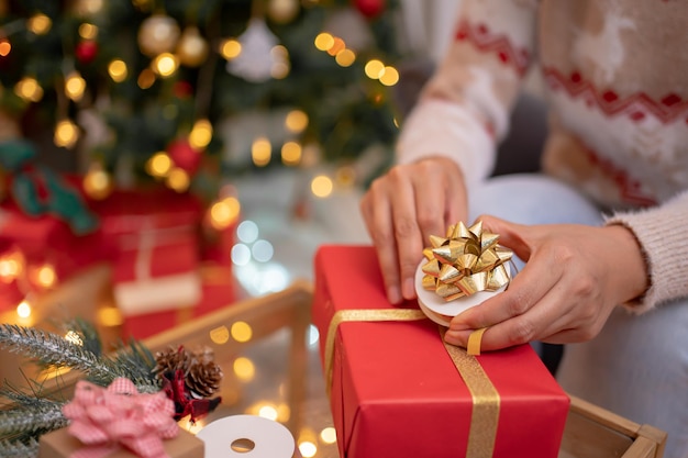 自宅でクリスマスと新年のパーティーのための贈り物とプレゼントを持つ女性。