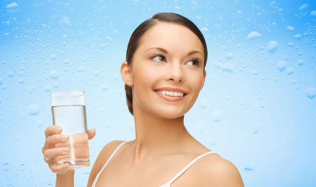 Photo woman with glass of water over wet blue background