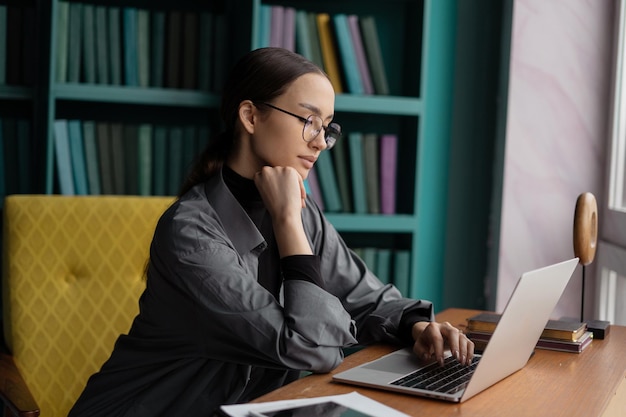 A woman with glasses is a freelancer who works in a coworking space