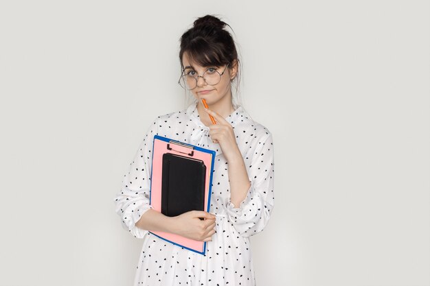 Woman with glasses is holding some folders