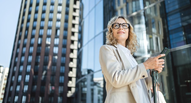 A woman with glasses is a marketing expert working in an office Uses a phone device