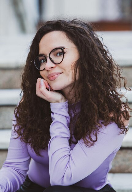 A woman with glasses on and a purple shirt