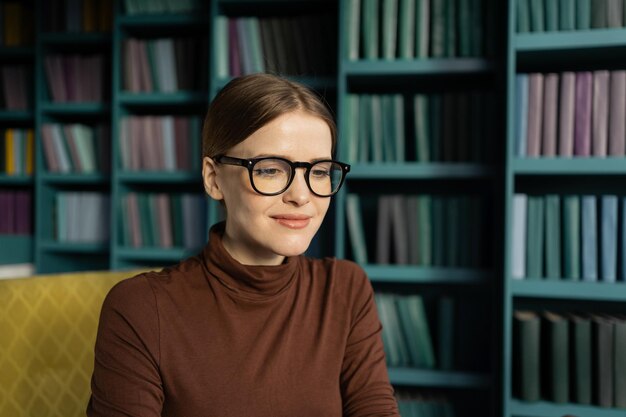 A woman with glasses reads a portrait in the office