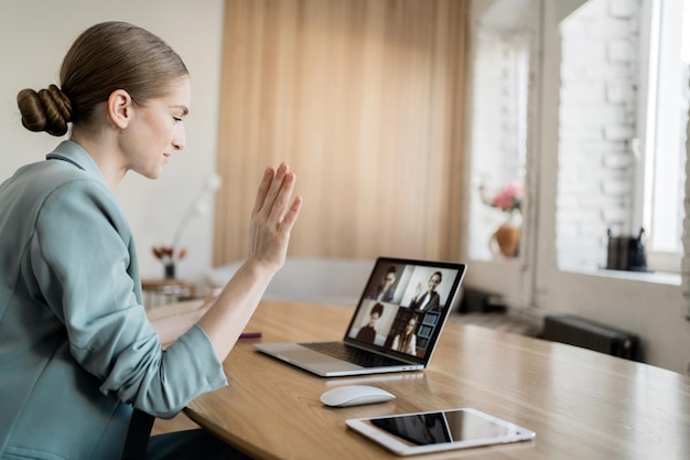 A woman with glasses works uses video communication makes a\
report to the company on finances