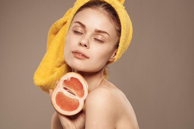 손에 그레이프프루트를 들고 있는 여자 깨 ⁇ 한 피부 맨 어깨 스파 건강 치료 고품질 사진