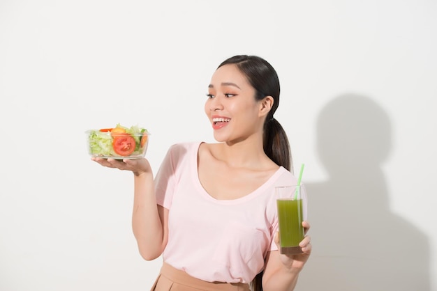 Woman with green detox smoothies, salad in glass bowl isolated on white background. Proper nutrition, vegetarian food, healthy lifestyle, dieting concept. Area to copy space