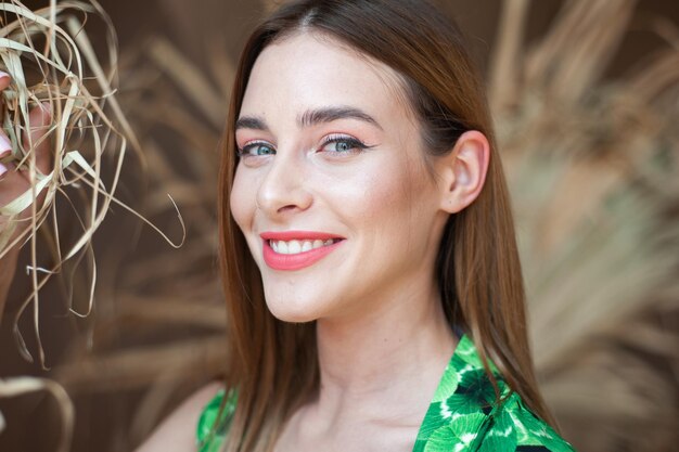 A woman with a green dress and a green top smiles at the camera.