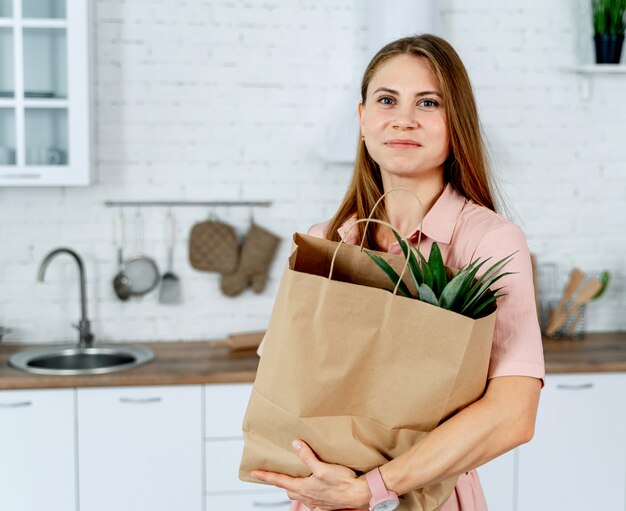 手で食料品店のパケットを持つ女性。