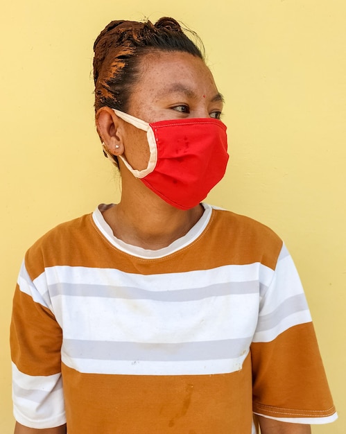 Woman with hair dye standing against yellow wall