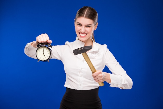 Woman with hammer and alarm clock