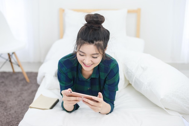 家でベッドに横たわっているに手を置いた女性