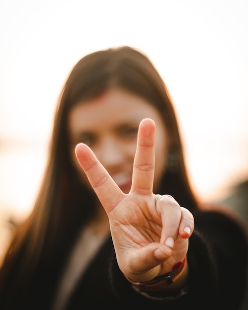 Foto una donna con una mano alzata e la parola pace sul davanti del viso