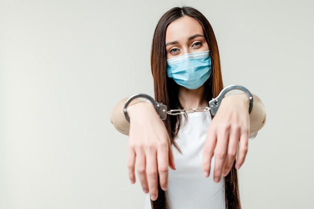 Woman with handcuffs wearing mask. quarantine concept