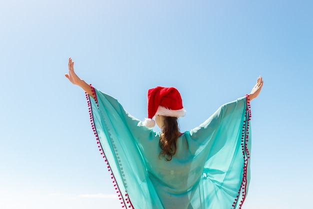 Woman with hands outstretched to the sky on the beach, 