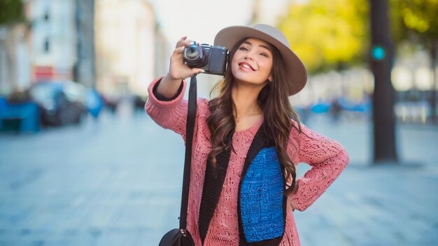 Photo a woman with a hat and a camera is taking a picture