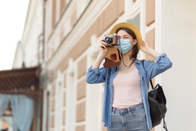 Donna con cappello e maschera per scattare foto