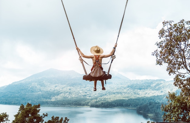 Woman with hat on a swing in Bali