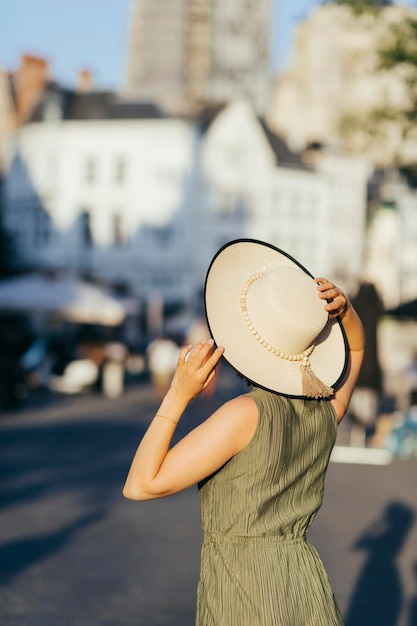 Woman with hat walking in city on a sunny day