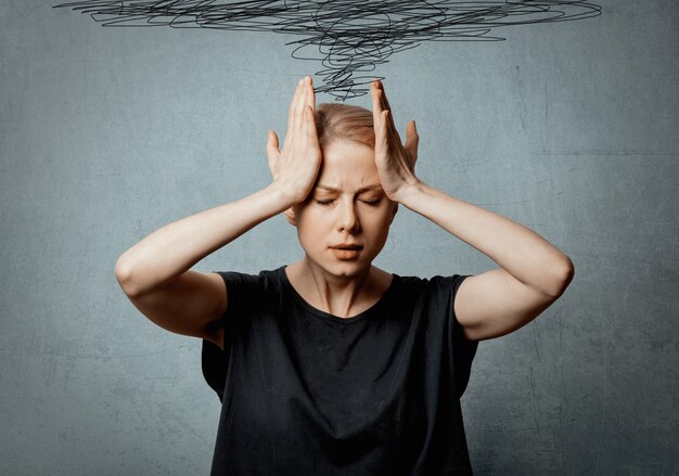 Woman with headache on grey space