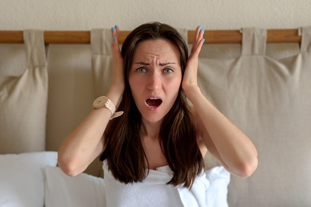 Woman with a headache holding her head with her hands