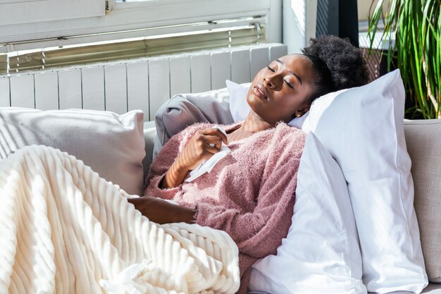 Woman with headache sitting under the blanket