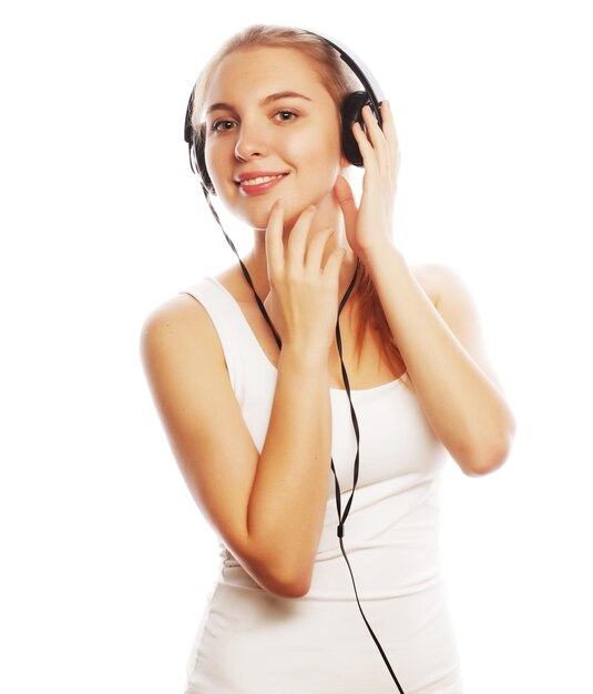 Женщина в наушниках слушает музыку Музыка девочка-подросток изолирована на белом
