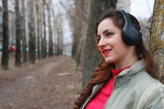 Woman with headphones in park autumn