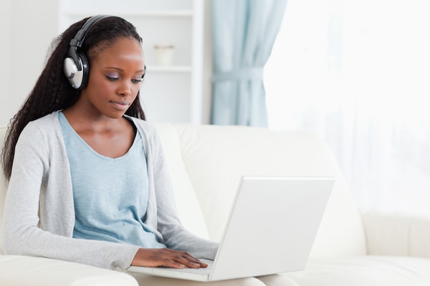 Woman with headphones on working on laptop