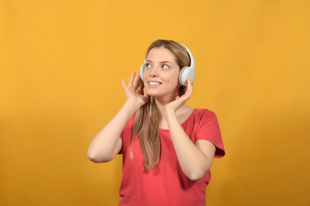 A woman with headphones on and a yellow background