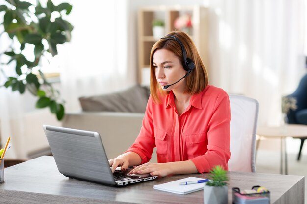 woman with headset and laptop working at home
