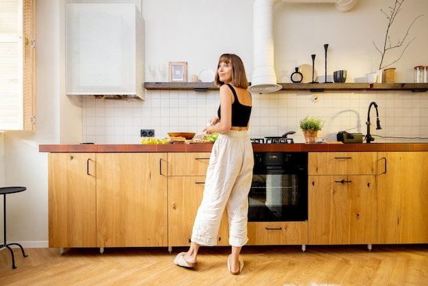 Donna con cibo sano in cucina a casa