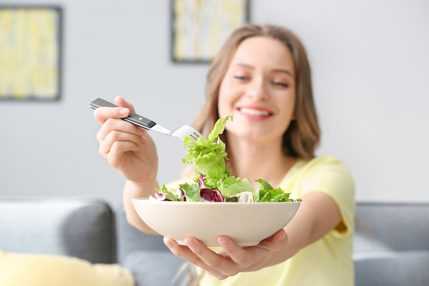 自宅で健康的な野菜サラダを持つ女性