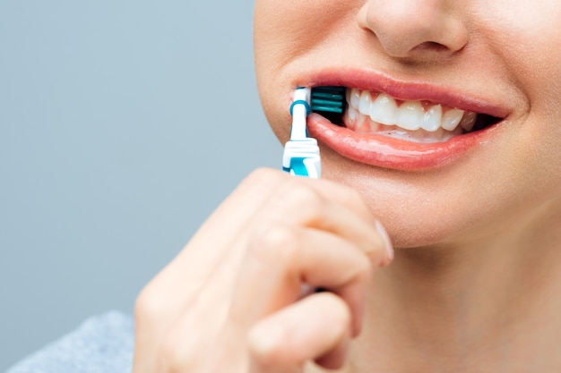 Woman with healthy white teeth holds a toothbrush and smiles oral hygiene concept