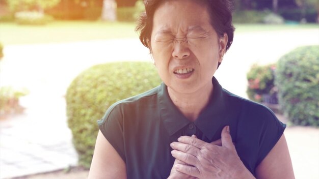 Photo woman with heart attack standing in park