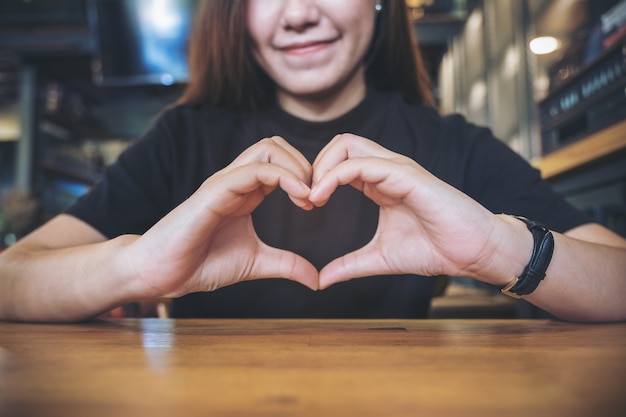 woman with heart hand sign