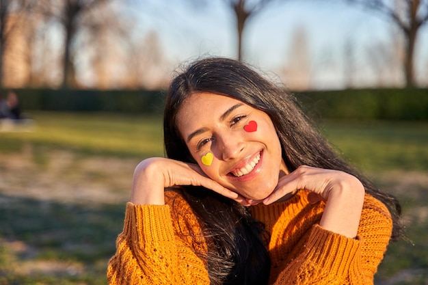 Donna con il cuore sulle guance e un gesto di amore e felicità