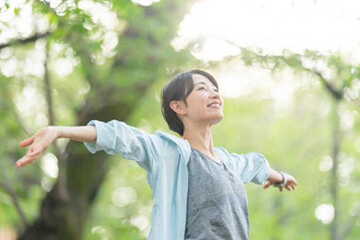 Photo 木の前で腕を伸ばした女性