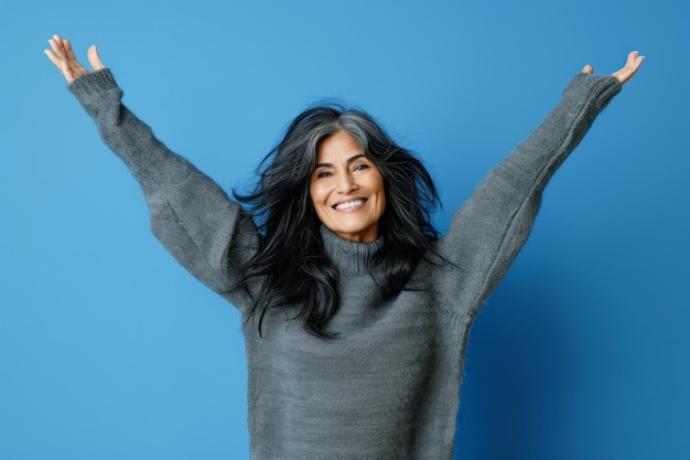 A woman with her arms up in the air over a blue background