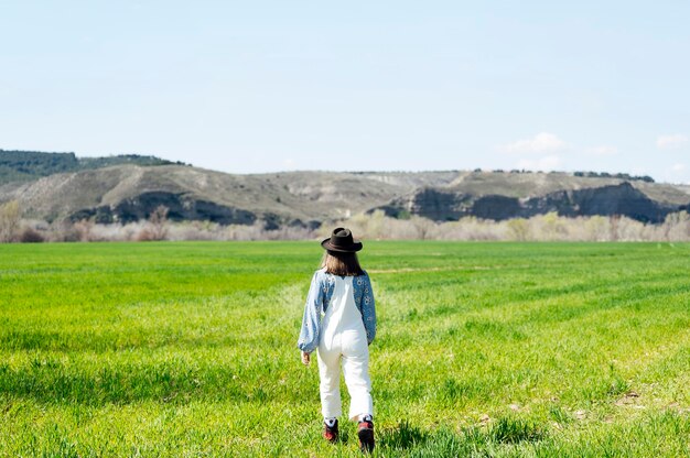 写真 フィールドを歩いている彼女の背中を持つ女性