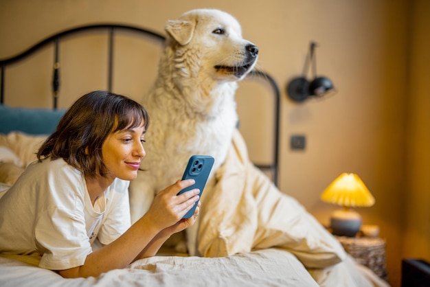 Photo woman with her dog lying on bed