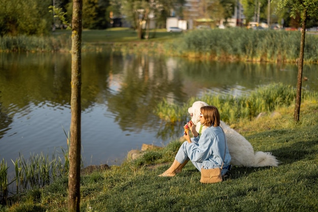 Woman with her dog near lake in park