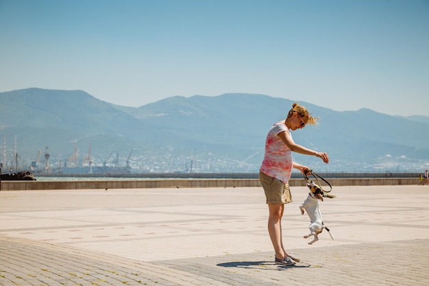 Woman with her dog playing on the open air