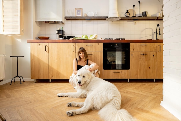 La donna con il suo cane si rilassa in cucina