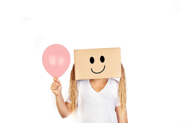 Woman with her head in a box happiness gesture drawn on it and holding a pink balloon