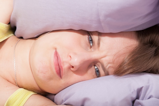 Photo woman with her head under her pillow trying to sleep