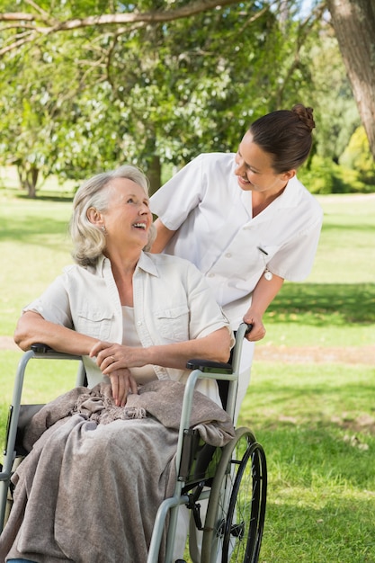 Woman with her mother sitting in wheel chair at park