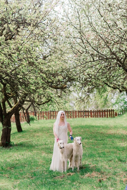 Woman with her russian wolfhound dogs in garden