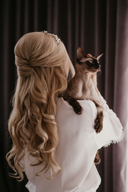 Foto donna con il suo gatto sphynx nelle sue mani