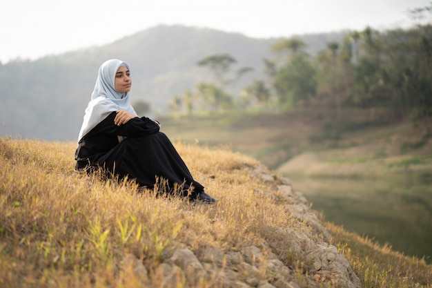 Donna con hijab seduto all'aperto